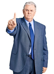 Senior grey-haired man wearing business jacket pointing with finger up and angry expression, showing no gesture