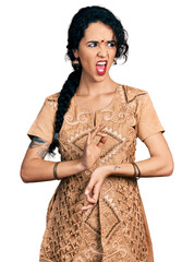 Young indian woman doing mudra with two hands angry and mad screaming frustrated and furious, shouting with anger. rage and aggressive concept. - obrazy, fototapety, plakaty