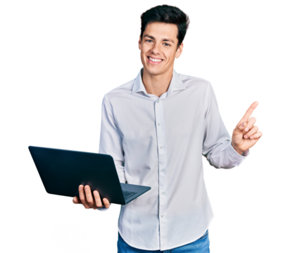 Young hispanic business man working using computer laptop smiling happy pointing with hand and finger to the side