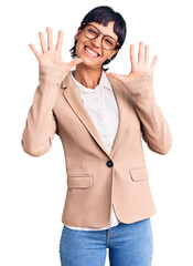 Young brunette woman with short hair wearing business jacket and glasses showing and pointing up with fingers number ten while smiling confident and happy.