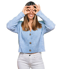 Young woman wearing casual clothes doing ok gesture like binoculars sticking tongue out, eyes looking through fingers. crazy expression.