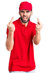 Young handsome man with beard wearing delivery uniform showing middle finger doing fuck you bad expression, provocation and rude attitude. screaming excited