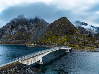Obraz na płótnie Canvas bridge to heningsvaer village with mountains in clouds on background