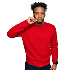 Young african american man with beard wearing casual winter sweater mouth and lips shut as zip with...