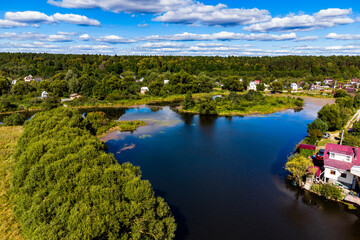 Naklejka premium A picturesque colorful view of the river area with densely built coastline. Lake Ogublyanka, Kaluga region, Russia