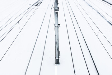 Railway top view background. Train track texture. White transportation background. Winter landscape. Snow on the railway. Icy train plaftorm. Train station covered in snow. Black lines on white.
