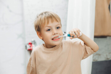 Little boy brushing his teeth in the bathroom at home