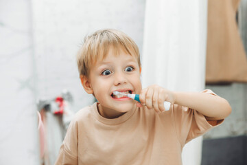 Little boy brushing his teeth in the bathroom at home