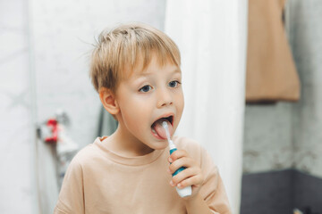 Little boy brushing his teeth in the bathroom at home