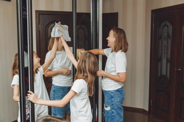 The concept of cleaning an apartment on the weekend. Mom and her children are cleaning the house,...