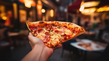 Foto op Plexiglas Closeup man hand holding slice of pepperoni pizza on blurred cafe background © GulArt