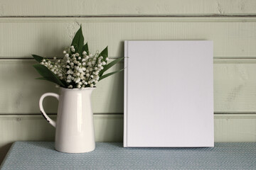 mockup book, album with an empty cover and lilies of the valley. Cottage interior. background, copy space. summer stage creator.