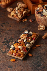 Mix of nuts and raisins on a brown rustic background.