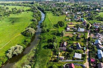 Rural landscape with a view of a village next to a flowing river, aerial view