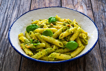 Penne with basil pesto sauce on wooden table
