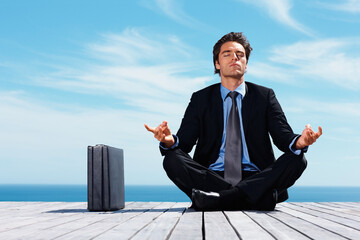 Meditation, briefcase and business man on blue sky for relaxing, positive mindset and solution. Corporate person, thinking and worker outdoors in yoga pose for mental health in career, work and job