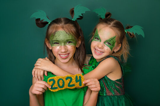 Girls dressed up as a green dragon, the symbol of the new year according to the Chinese calendar, hold the numbers 2024.