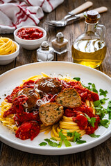 Linguine meatballs in bolognese sauce on wooden table