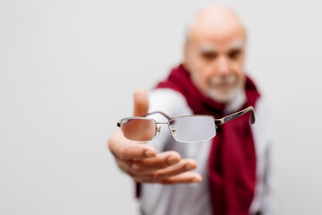 Vision correction and treatment. A mature man throws away his glasses after vision treatment. A...