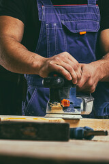 Worker grinds the wood of angular grinding machine