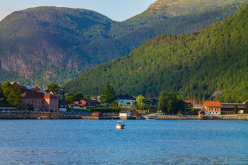 Fototapeta na wymiar Golden hour at Sogndal, a village Vestland county, Norway near a body of water, shown here with a motorboat.
