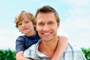 Father, son and portrait outdoor with piggyback for bonding, relationship and freedom with blue sky or happy. Family, man and boy child in nature with care and love for excitement, peace and support
