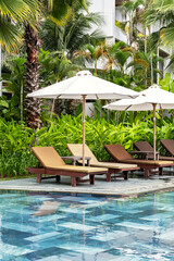 Empty beach chairs near swimming pool. Luxury tourist resort.
