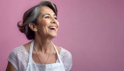 Encantadora imagen de una mujer mayor sonriente, con delantal de cocina y cabello blanco, inmersa en la cocina. La pared rosa crea un ambiente encantador, evocando la esencia de la cocina de la abuela