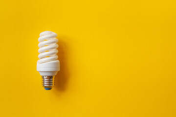 Energy saving light bulb on a orange background. Economical consumption of electricity. The concept...