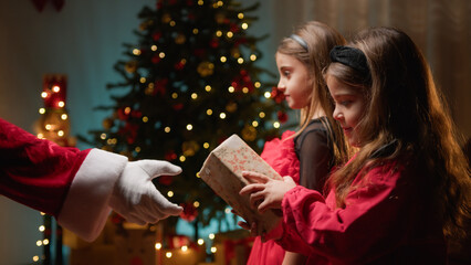 Little sisters receiving gifts from Santa Claus 