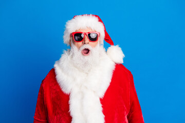 Photo portrait of pensioner senior man astonished reaction wear trendy santa claus costume coat isolated on blue color background