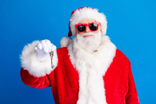 Photo portrait of mature pensioner man hold key house buyer wear trendy santa claus costume coat isolated on blue color background