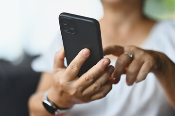 Close-up with a mature woman's hands using a smartphone