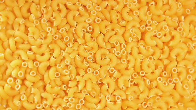 Uncooked Chifferi Rigati Pasta - Top View. Fat and Unhealthy Food. Classic Dry Macaroni, Rotating Background. Italian Culture and Cuisine. Raw Golden Pasta Texture - Right Rotation