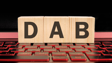 DAB written on wooden cubes on the laptop keyboard