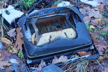 one old black broken glass TV picture tube lies on the ground on the street