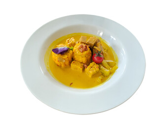 yellow corn soup in serving bowl, flat lay on white plate, isolated on white background