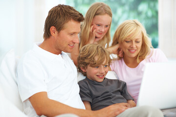 Laptop, video or streaming with a family on a sofa in the living room of their home together for entertainment. Parents, children or computer for subscription service with a mother, father and kids