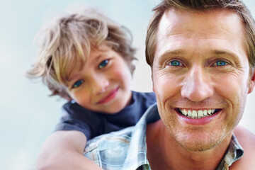 Father, son and portrait or smile with piggyback for bonding, relationship and freedom with blue sky in nature. Family, man and boy child with playing, care and love for happiness, peace and support