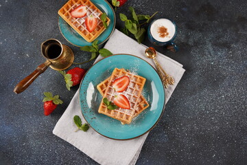 Belgian waffles with fresh strawberries, sugar powder and mint leaves