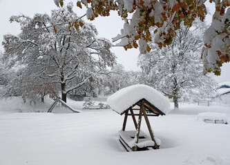 Gazebo covered with snow in a village square. - 687114858