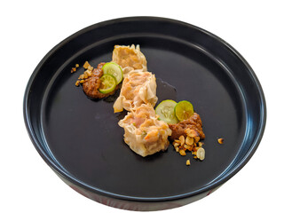 delicious siomai served on black plate isolated