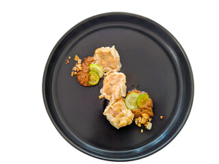 delicious siomai served on black plate isolated, top view