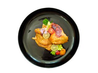 baked chicken served on black plate flat lay, isolated