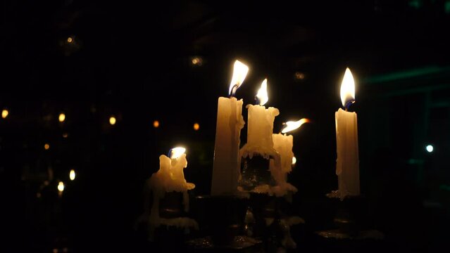 Burning candles on candelabra in night, melted wax.