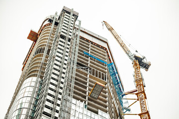 FRANKFURT, GERMANY - July 19, 2023: Building a skyscraper with a crane. Construction of high-rise...