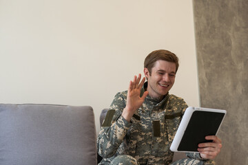 cheerful military man using digital tablet and having video call in office