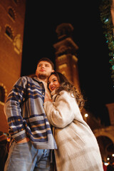 Obraz premium Young stylish couple in love in checkered coats in Verona at Piazza dei Signori