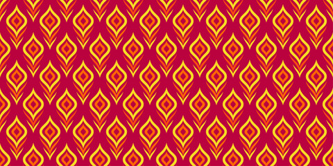 Seamless pattern of exotic peacock feathers in red and yellow colors for wallpaper and background