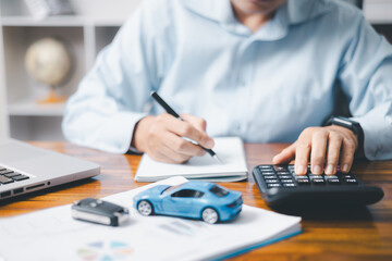Toy Car In Front Of Businessman Calculating Loan. Saving money for car concept, trade car for cash...